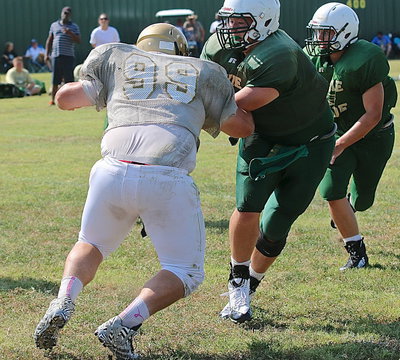 Image: Gladiator right offensive tackle John Byers(99) slows down the pursuit of a pair of Eagles.