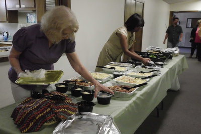 Image: IMA volunteers Barbara Little and Dorothy Anderson make sure everything is just right before the meal.