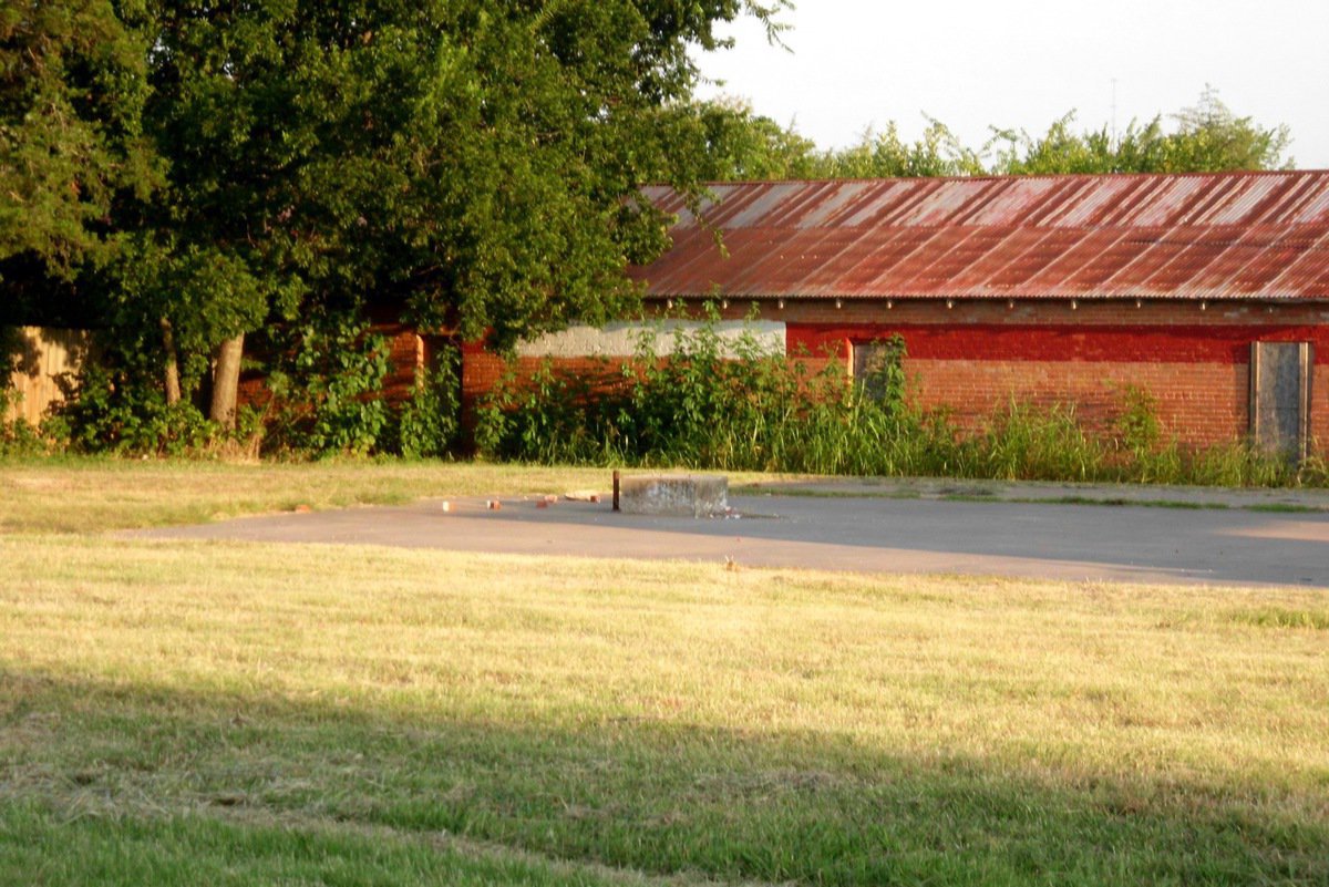 Image: Weeds are up to the roof in front of this building that the city owns.