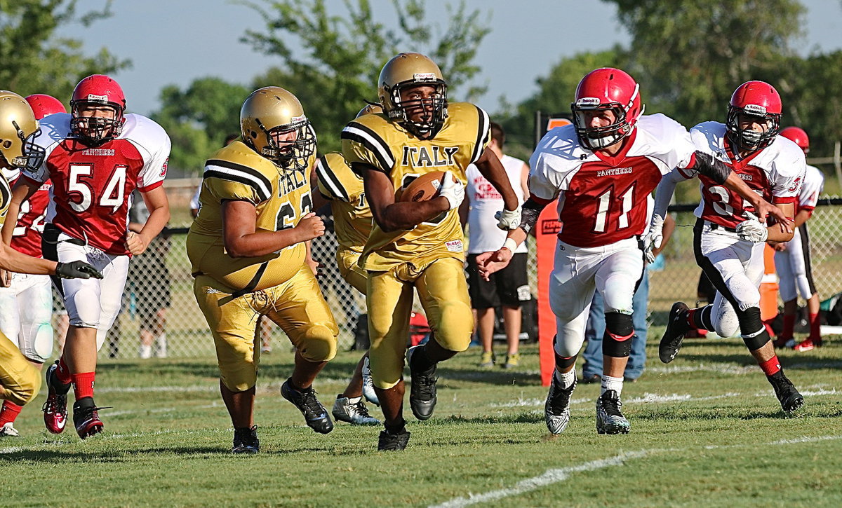 Image: He gone! — Italy’s Gabe Fernandez(62) clears a path for teammate Jaray Anderson(10) who breaks thru for a long run against the Panthers.