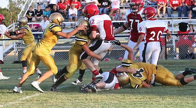 Image: Italy’s Micah Escamilla(4) hangs on to a Panther runner as Blake Brewer(32) moves in to execute a form tackle.