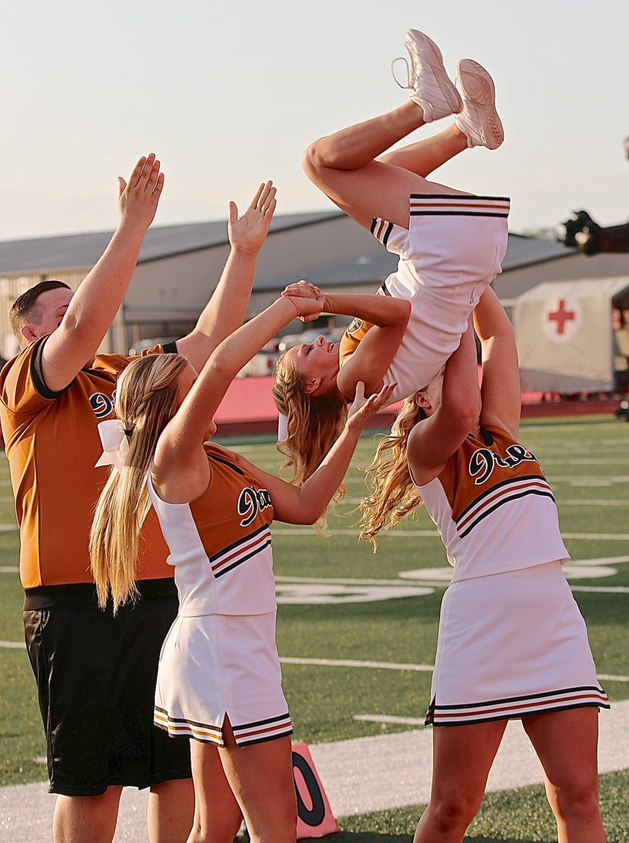 Image: Italy High School cheerleaders Zac Mercer, Annie Perry and Madison Washington hope for the best as Britney Chambers executes a tricky dismount after a stunt.