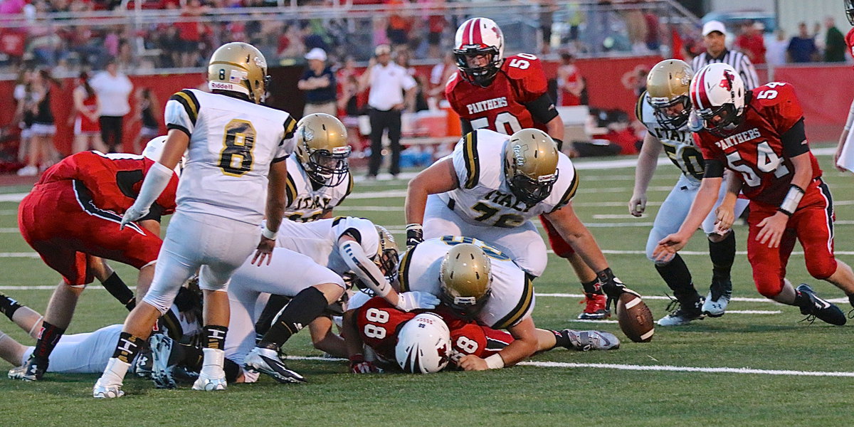 Image: After a hit by defensive end John Byers(60), the ball pops out from a Panther ball carrier. Gladiator teammate Colin Newman(76) attempts to recover the pesky pigskin.