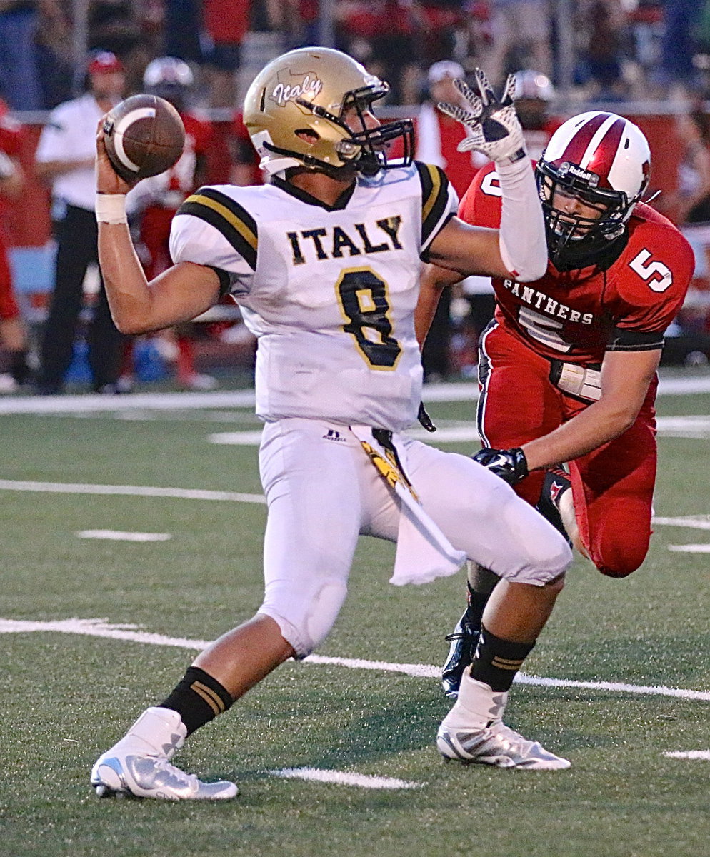 Image: Gladiator quarterback Joe Celis(8) hangs tough under the threat of a Panther attack.