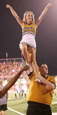 Image: Italy High School cheerleader Britney Chambers reaches the fans in the cheap seats thanks to fellow cheerleader Zac Mercer who offers her a boost.