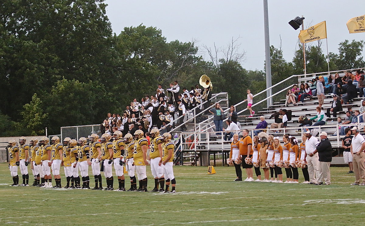 Image: Players, coaches, cheerleaders, band members and fans await the coin toss results.