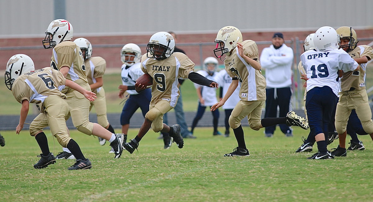 Image: B-team Gladiator John Hall, Jr.(9) sneaks behind his wall of blockers to gain more yards.