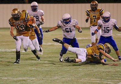 Image: A diving block by Clay Riddle(77) slows up three Polar Bear chasers as Coby Jeffords(10) takes advantage for more yards.