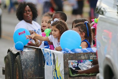 Image: Kochenna Houston and the Pre-K students enjoy throwing candies to the homecoming crowds lining the streets.