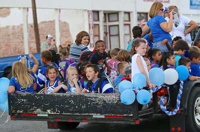 Image: Teachers’ Susan Jacinto and Kim Evans ride with her spirited 1st and 2nd grade students during Milford’s homecoming parade.