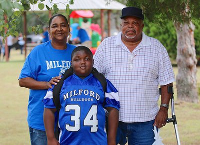 Image: Milford third grader, DeMarcus “D-Man” Rankin(34) poses with his Grandma Jannie Rankin, a Teacher’s Aide for the school, and his grandfather Bobby Rankin following the pep rally in the park.