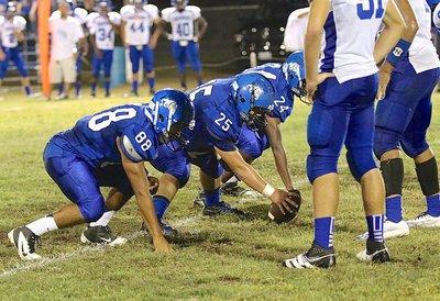Image: Juan Venegas(25) prepares to snap while being flanked by teammates Adrian Ojeda(88), a senior, and Jarvis Harris(24), a sophomore.