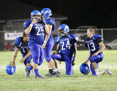 Image: Juan Venegas(25), a junior center, buckles up after an injury timeout as he and teammates Jaquay Brown(11), Tyler Fedrick(9), Jarvis Harris(24) and Keith Kayser(13) ready to push their way into the endzone.