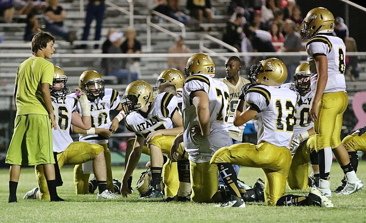 Image: Team managers Brentlee Grant and John Hall, Jr., water the Gladiator defense during an injury timeout.