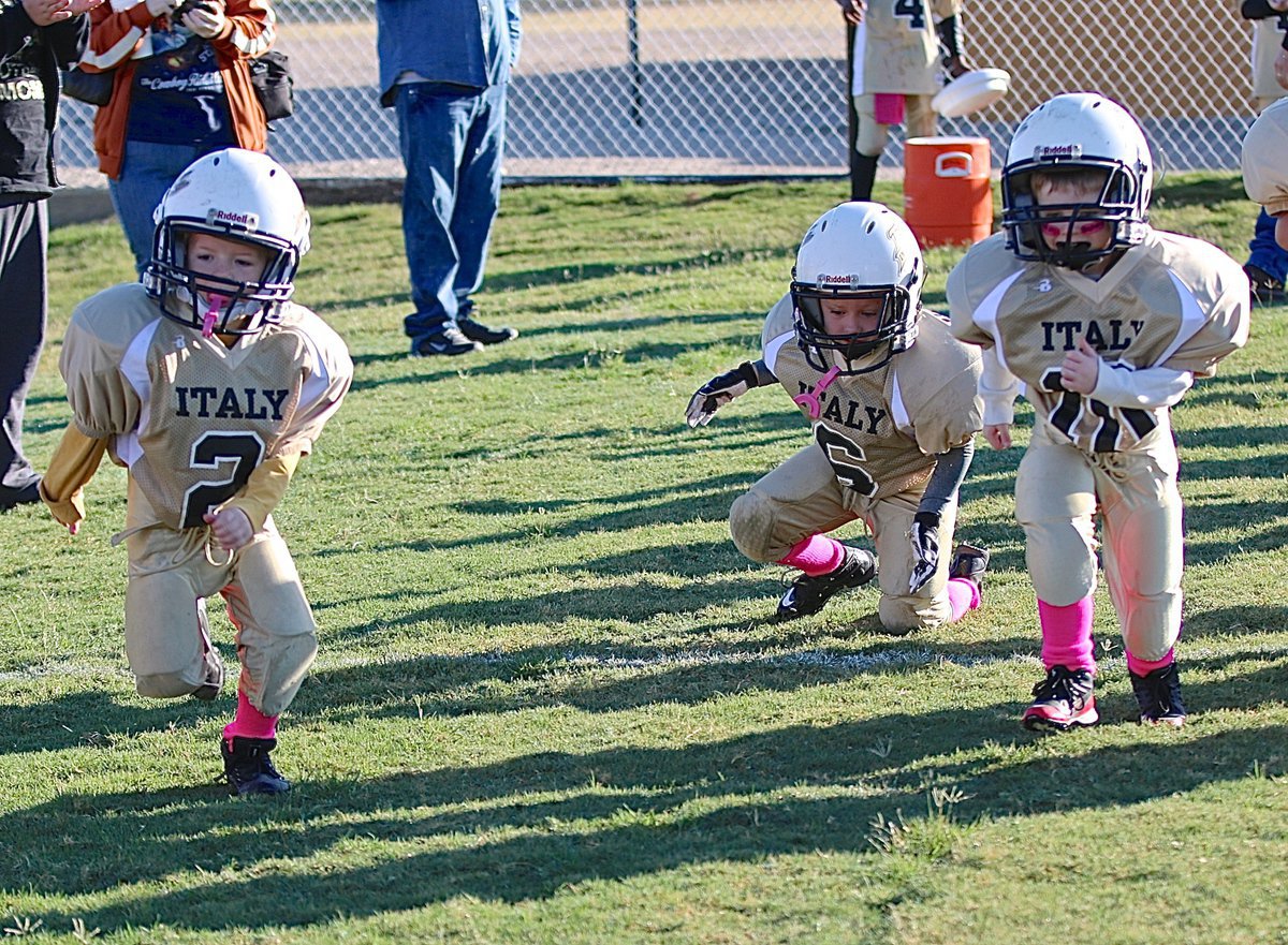 Image: IYAA C-team Gladiators Koda Harris(2), Grant Morgan(6) and J.C. Smith(10) hit Willis Field running, sort of, as they prepare to take on the Mildred Eagles.