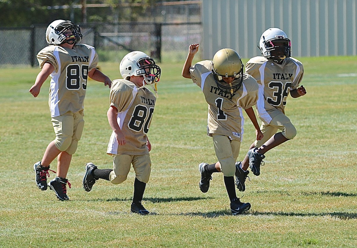 Image: The IYAA B-team Gladiators celebrate their first win of the season as Watt Ryan(89), Jordan Clamon(80), Christopher Adams(1) and Willie Talton(36) enjoy the moment.