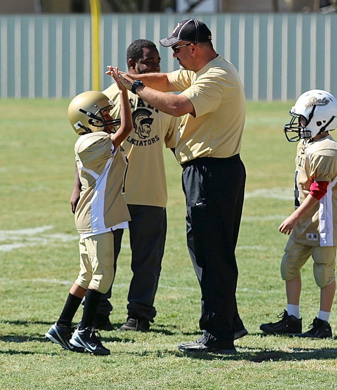 Image: Christopher Adams(1) and Preston Walker(4) receive congratulations from head coach Mark Souder and assistant coach Brian Anderson.