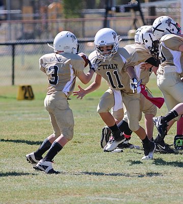 Image: IYAA A-team Gladiator quarterback Creighton Hyles(11) pitches to running back Ty Cash(3).