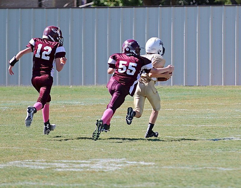 Image: IYAA A-team receiver Kort Holley(10) hauls in a pass and then heads for the endzone with Mildred defenders on his tail pad.