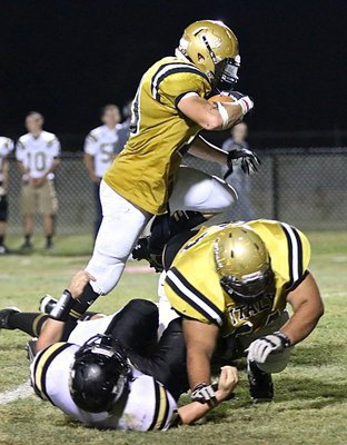 Image: Italy flat ran over the Dawson Bulldogs this past Friday night to secure a homecoming win and improve their district record to 3-2. Here Coby Jeffords(10) leaps over a pancake block from his right guard Ty Hernandez(64).