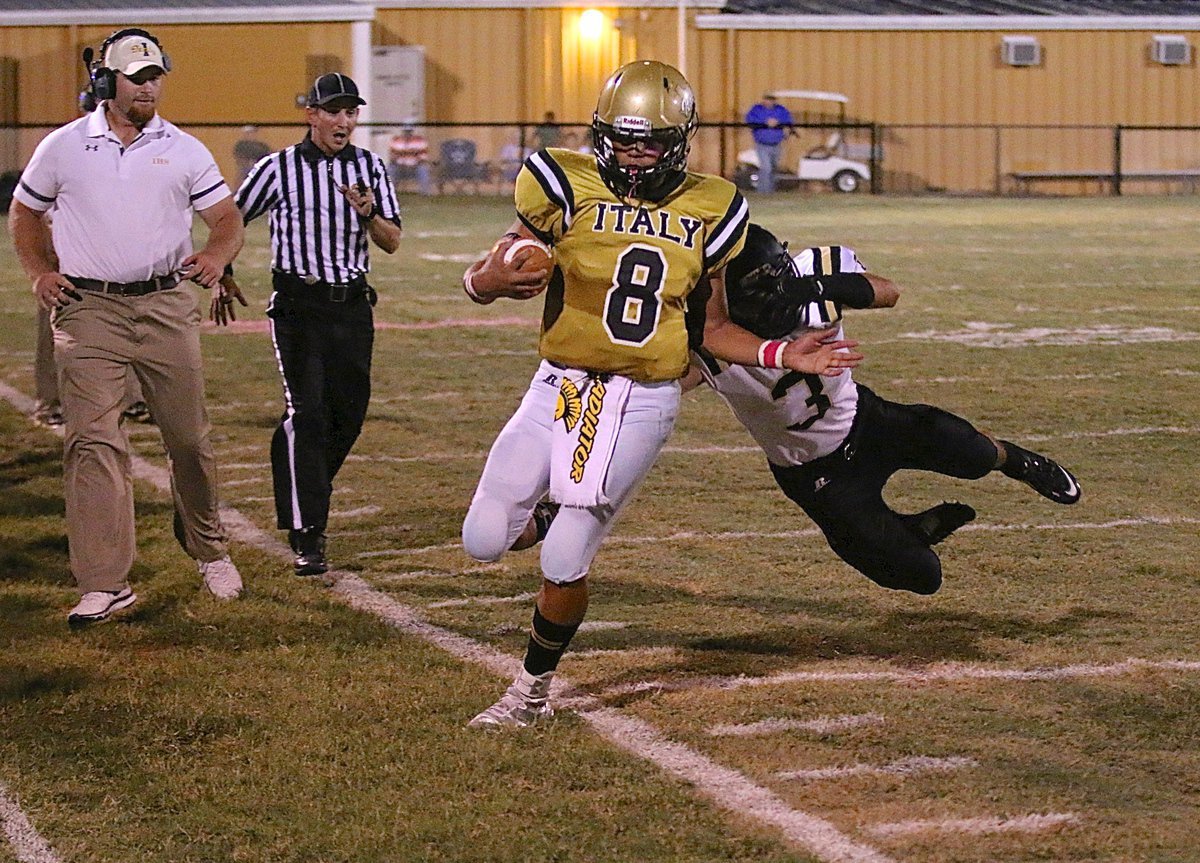 Image: Assistant coach Jon Proud keeps an eye on quarterback Joe Celis(8) as Celis is forced out-of-bounds by a Bulldog defender.