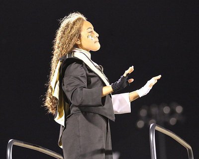 Image: Assistant drum major Vanessa Cantu directs the band during homecoming.
