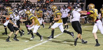 Image: Senior tailback Coby Jeffords(10) convoys his way downfield behind blockers Clay Riddle(77), Kyle Tindol(12) and Clayton Miller(6) with Italy running over the Dawson Bulldogs Friday night.