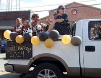 Image: The IYAA B-team Gladiator cheerleaders are trucking along during the homecoming parade with cheer sponsors Kia Hugghins and Melissa Souder having fun as well.
