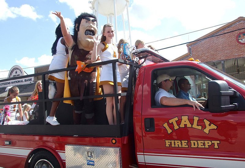 Image: Jr. High cheerleader and Gladiator mascot Virginia Stephens rides in style with an Italy fire truck serving as their war chariot during Italy’s 2014 Homecoming Parade. Jon Proud and Brad Chambers are in the cab.