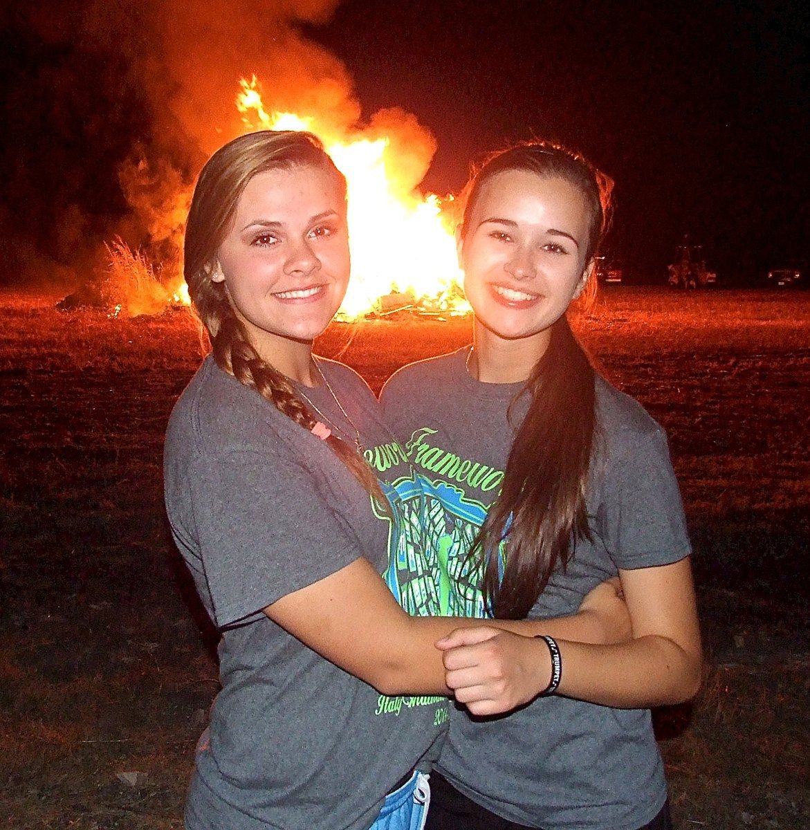 Image: Band members Lillie Perry and Amber Hooker pose in front of the bonfire.