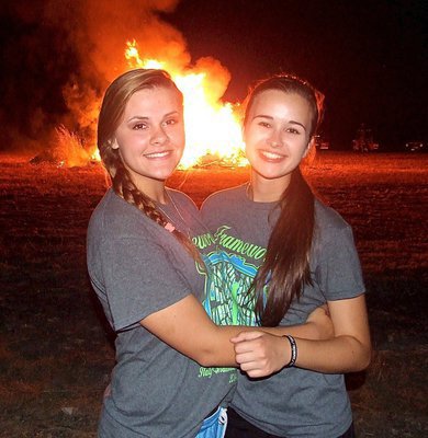 Image: Band members Lillie Perry and Amber Hooker pose in front of the bonfire.