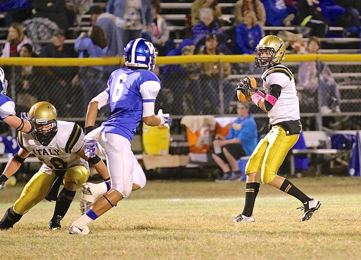 Image: Ryan Connor(7) takes a few snaps at quarterback for Italy as Coby Jeffords(10) tries to buy Connor some time to scan the field.