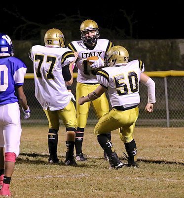 Image: Cody Boyd(15) covers a punt at the Bulldog 1-yard line and receives congratulations from Gladiator teammates Clay Riddle(77) and John Escamilla(50).