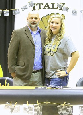 Image: Italy ISD Principal Lee Joffre congratulates Jaclynn Lewis on committing to Texas Lutheran to play softball for the Lady Bulldogs.