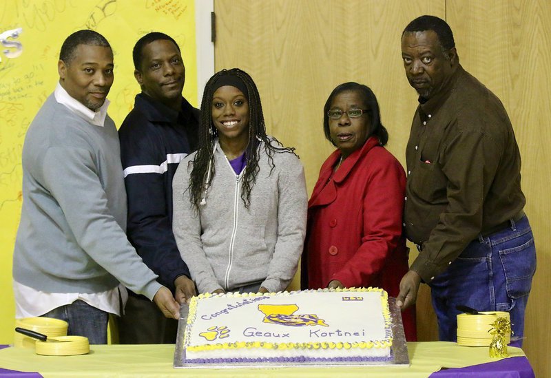 Image: Italy senior Kortnei Johnson displays her LSU cake with assistance from her summer track coach Keith Herring and father James Johnson on the left and aunt and uncle Wanda and Danny Jennings.