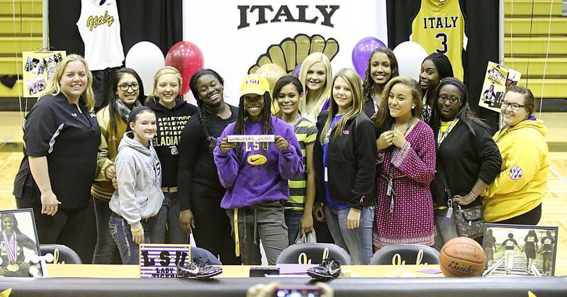 Image: All together now, many members of the Italy Lady Gladiator track and basketball teams join senior Kortnei Johnson as she holds the baton revealing LSU as her school of choice. Pictured (L-R) are Coach Melissa Fullmer, Lizzie Garcia, Tara Wallis, Brycelen Richards, Taleyia Wilson, Kortnei Johnson, Alex Minton, Annie Perry, Brooke DeBorde, Emmy Cunningham, Vanessa Cantu, Janae Robertson and basketball managers Brenya Williams and Rebekah Corley.
