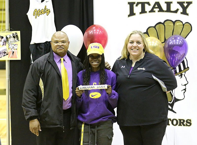 Image: Track coaches Bobby Campbell and Melissa Fullmer support senior track star Kortnei Johnson as she displays the Louisiana State University baton, Johnson’s college choice to continue her track career.
