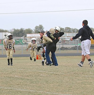 Image: Game managers Bryce DeBorde, Julius Williams and Barry Grant rush the field to celebrate with the C-team players after Italy’s Pre-K thru 2nd Grade Gladiators won the Superbowl.