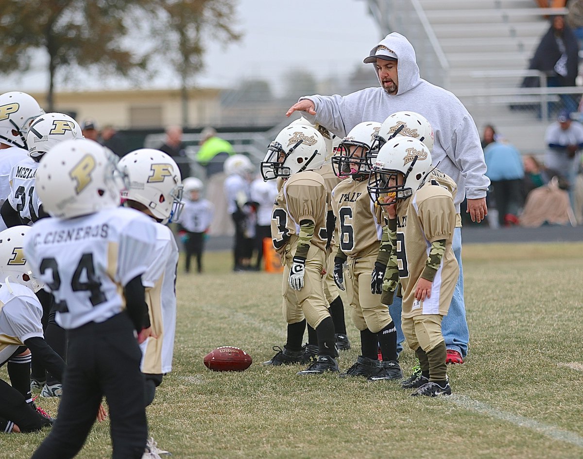 Image: Offensive line coach Barry Byers talks assignments with Ryland Cagle(20), Elijah Davis(18), center Ramzi Holt(33), Grant Morgan(6), Gavin Vazquez(56) and Jayden Hernandez(9).