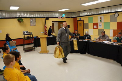 Image: Mr. Joffre hands out the High School’s gifts to the school board.