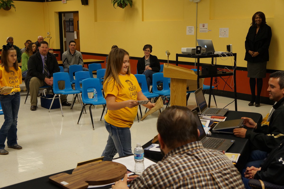 Image: Hailee Mathers presents one of the gifts to the school board.