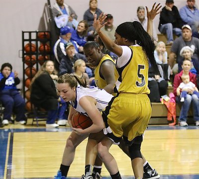 Image: Lady Gladiators Taleyia Wilson(22) and teammate Janae Robertson(5) harass a Frost rebounder.