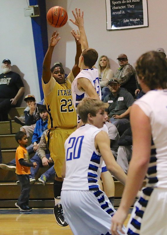 Image: Italy’s Kenneth Norwood, Jr.(22) shoots over an outstretched paw of a Polar Bear.