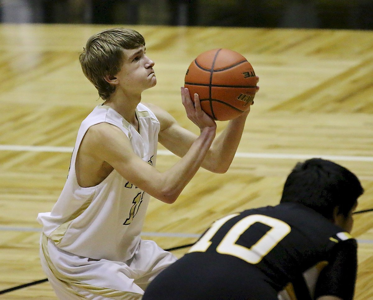 Image: Garrett Janek(12) takes aim from the free throw line.