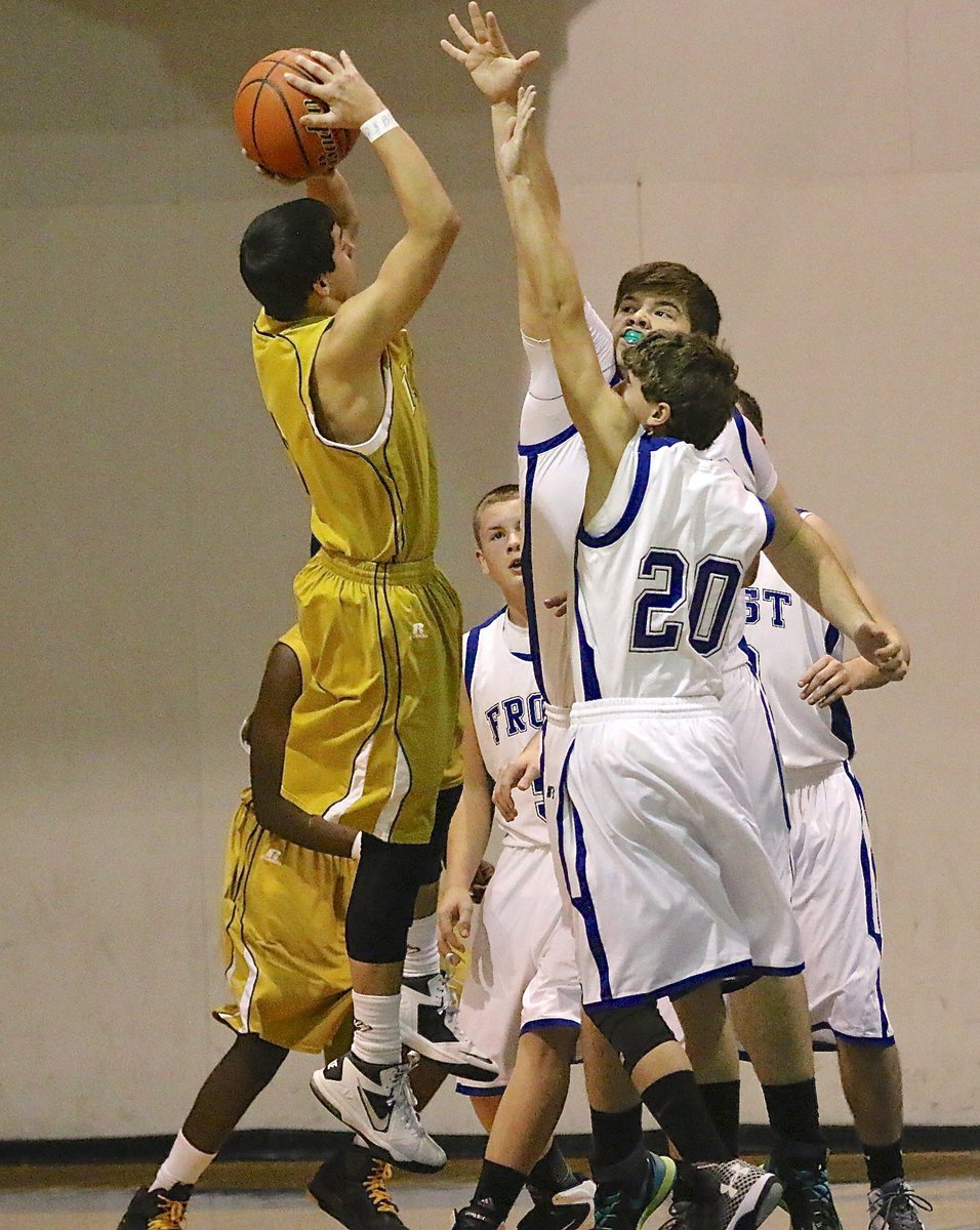 Image: JV Gladiator Gary Escamilla(2) rises up to take a jump shot over a couple of Frost Polar Bears defenders. Italy outlasted Frost 41-33 for the win in what proved to be a physical contest.