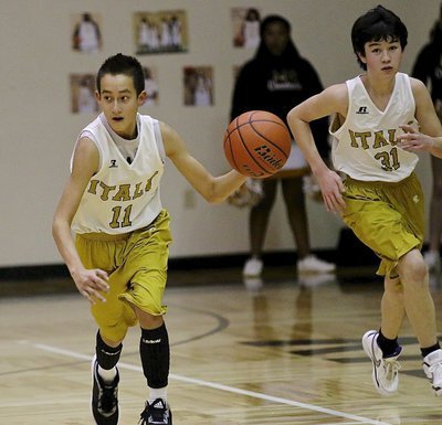 Image: 7th Grader Matthew Monreal(11) rushes the ball up the court with teammate Cade Tindol(31) filling the wing.
