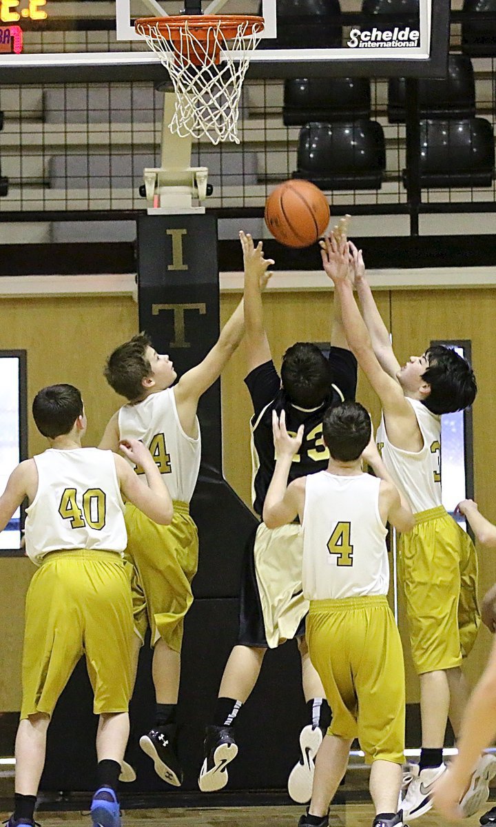 Image: 7th Graders Tanner Chambers(14) and Cade Tindol(31) reach for a defensive rebound.