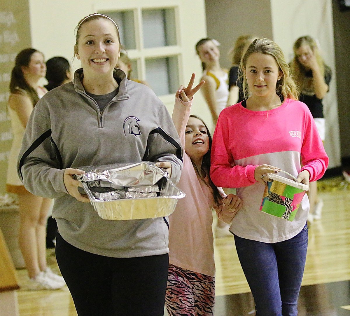 Image: Lady Gladiator softball players Jaclynn Lewis and Britney Chambers raise money for their club by selling grill cheese sandwiches which is always a homerun with fans. Morgan Chambers pitches in for the cause.