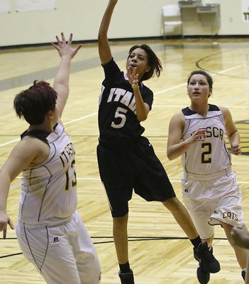 Image: T’Keyah Pace(5) dribbles into the paint and puts up a shot over Itasca defenders.