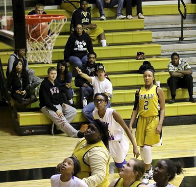 Image: Emmy Cunningham(2) drops in a three-bomb as indicated by JV Gladiator Gary Escamilla in the stands. Cunningham finished with 27-points against Dallas Gateway.